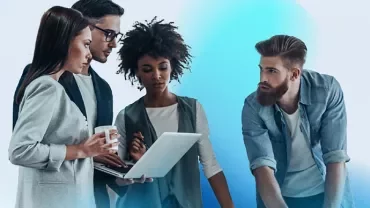 an image with a blue and white background and two males and two females engaging in a discussion and looking at a laptop