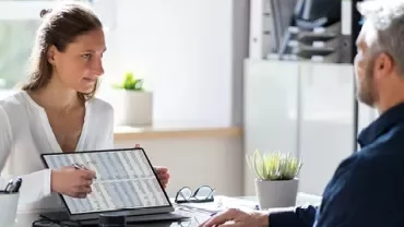 Laptop con hojas de cálculo y calculadora, indicando reportes y análisis financiero.