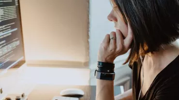 Woman working on code at a computer desk