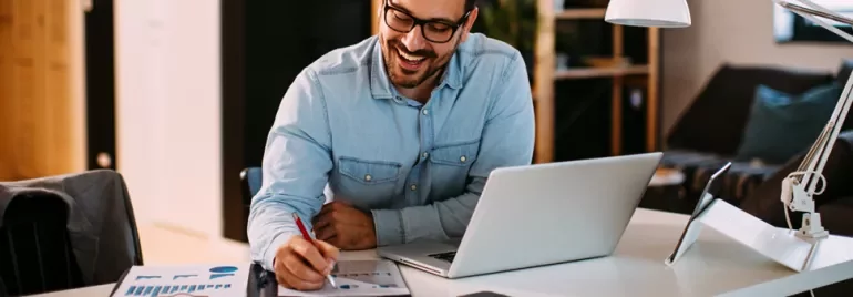 Man sitting on a desk with his laptop